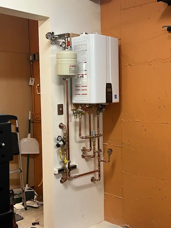 Plumbing technician inspecting water heater connections in Sunrise Manor